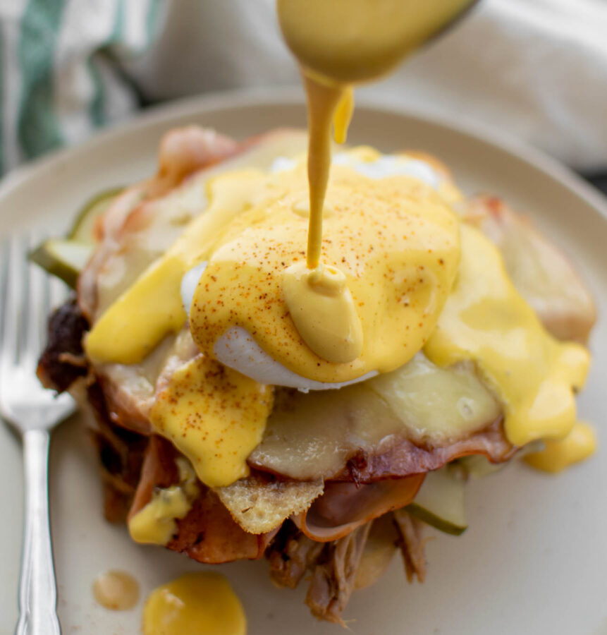 Hollandaise being poured onto the Cuban Eggs Benedict.