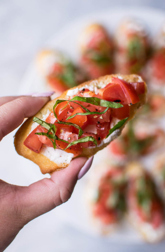 holding a piece of Italian Bruschetta 