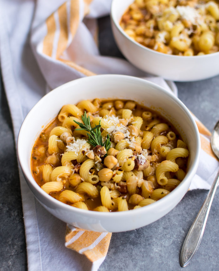Pasta e Fagioli in two bowls with cheese and rosemary