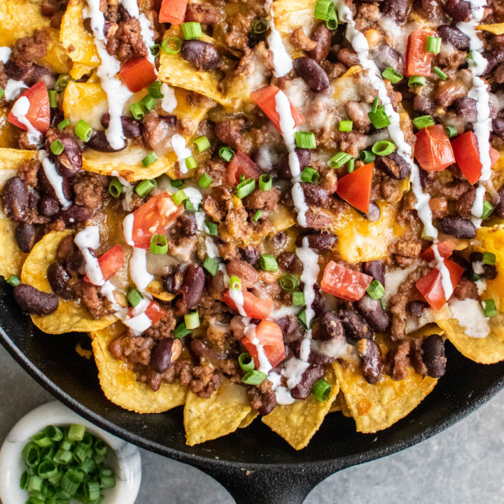 Baked Chili Nachos in a cast iron skillet.