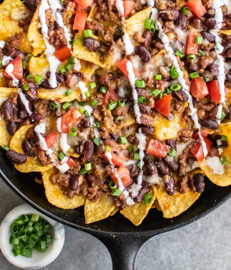Baked Chili Nachos in a cast iron skillet.