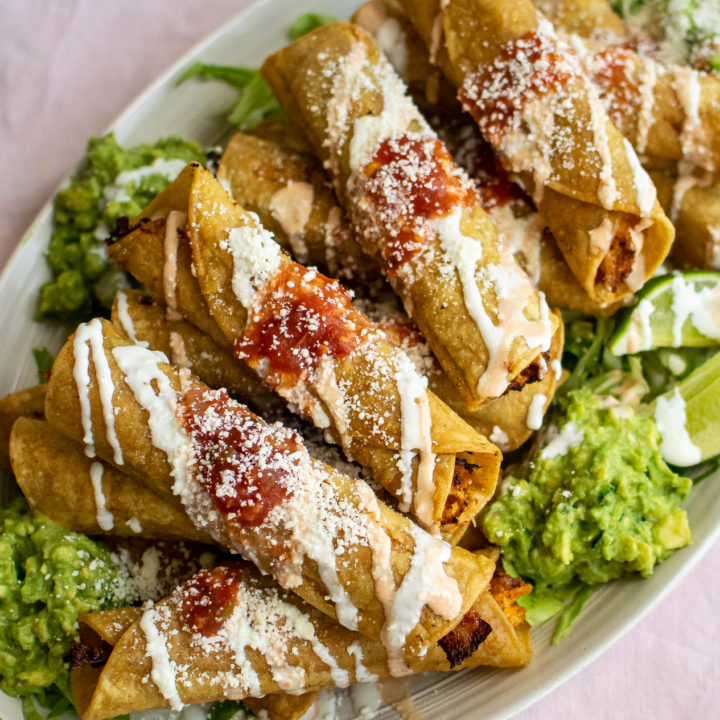 Leftover Turkey Taquitos with toppings on a platter.