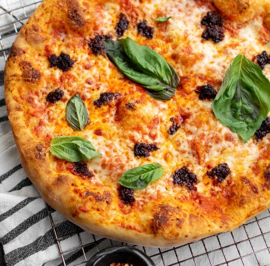 Close up of the Pizza with 'Nduja and Tomato Cream Sauce and fresh basil on top.