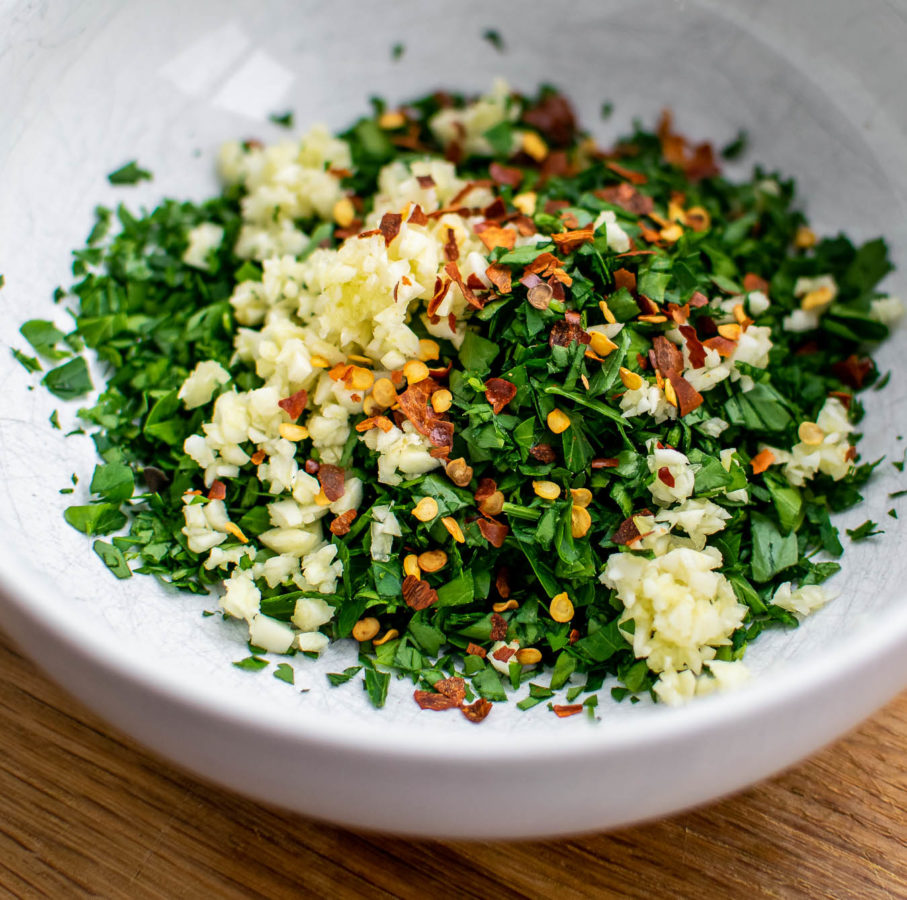 Parsley, oregano, garlic and red pepper flakes in a bowl.