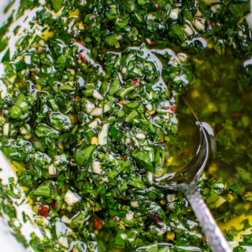 Chimichurri in a bowl with a serving spoon.