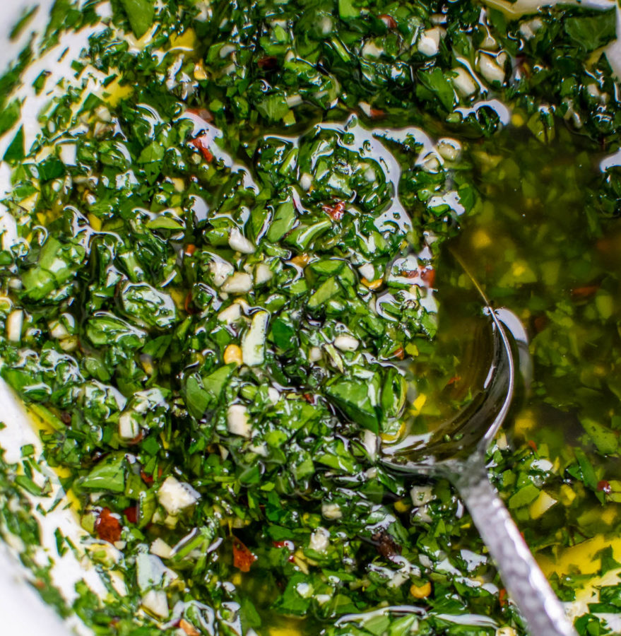Chimichurri in a bowl with a serving spoon. 