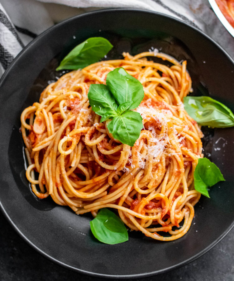 Pasta al Pomodoro in a bowl with fresh basil and cheese.