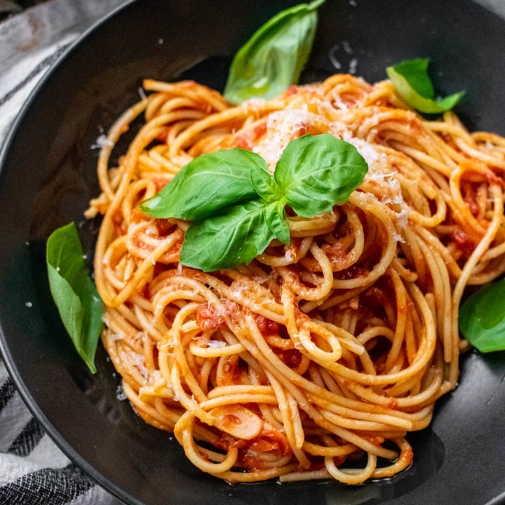 Pasta al Pomodoro in a bowl with fresh basil and cheese.