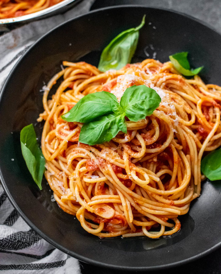 Pasta al Pomodoro in a bowl with fresh basil and cheese.