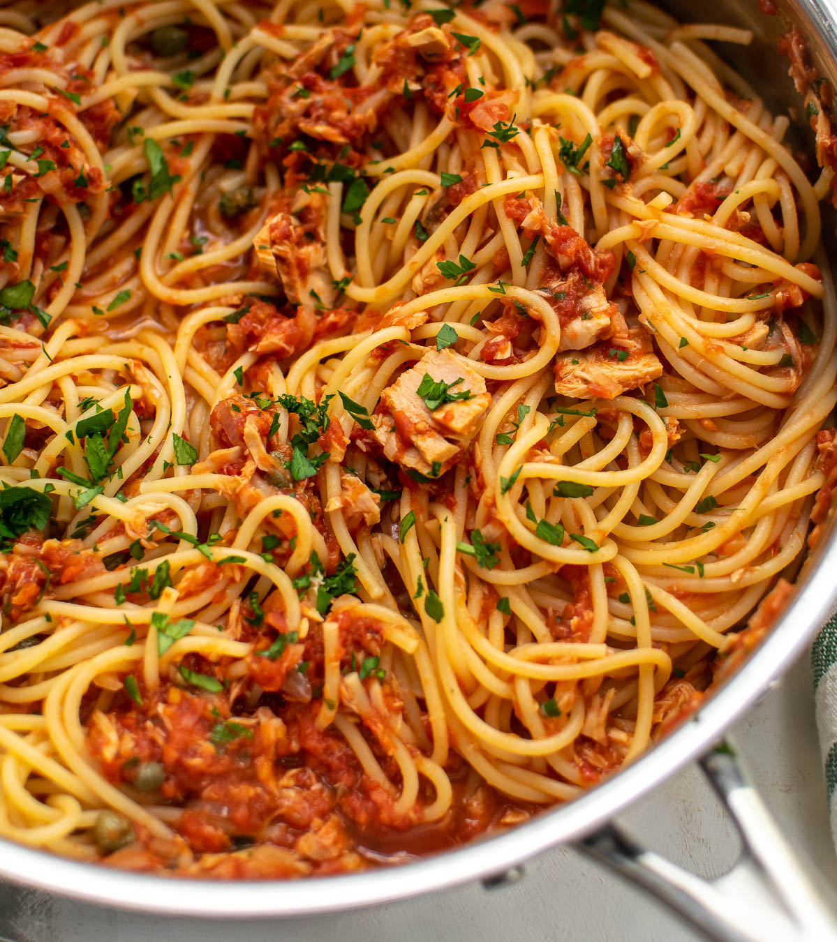 Close up shot of Spaghetti with Tuna and Tomatoes in a pan.