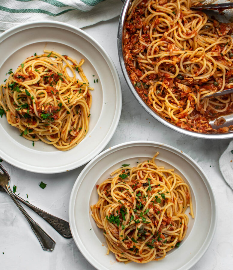 spaghetti with tuna and tomatoes served in bowls.