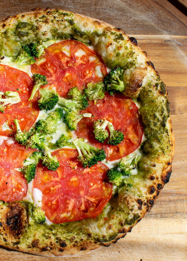 pesto pizza with tomatoes and broccoli.